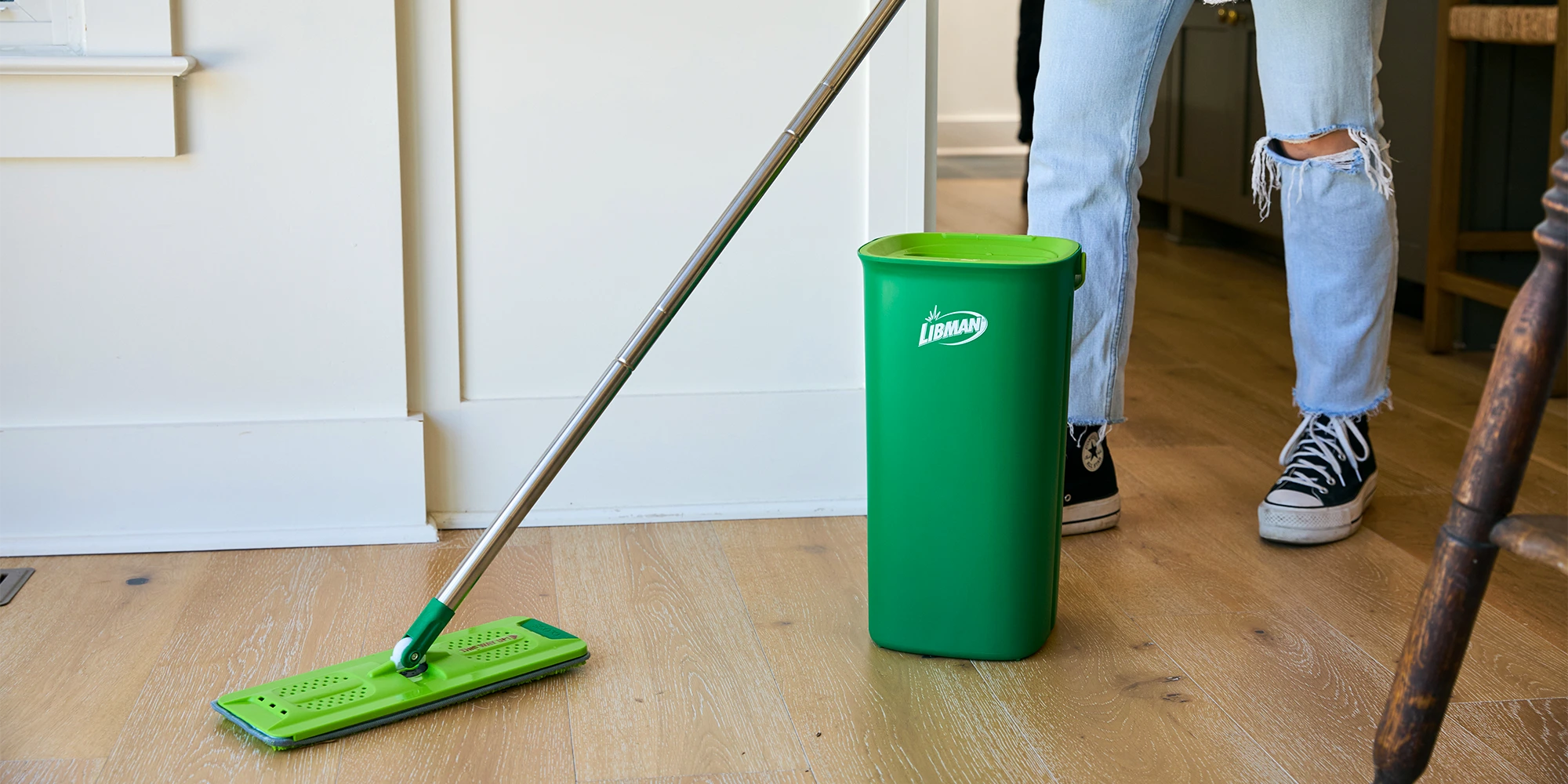 Person using flat mop to clean wood flooring