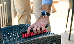 Person using scrub brush to clean outdoor furniture